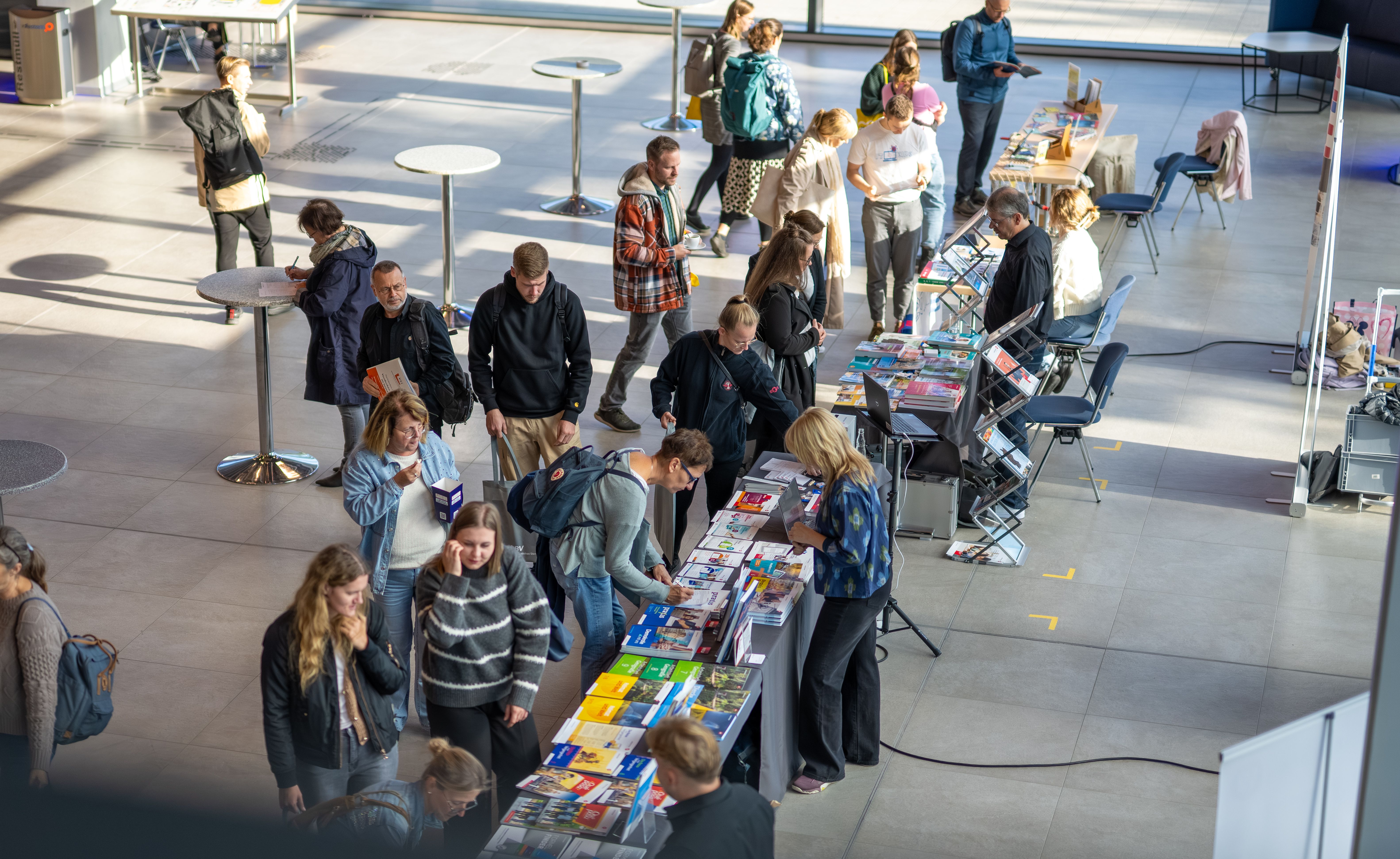 Lehrkräfte schauen an einem mobilen Messestand Bildungsmedien an
